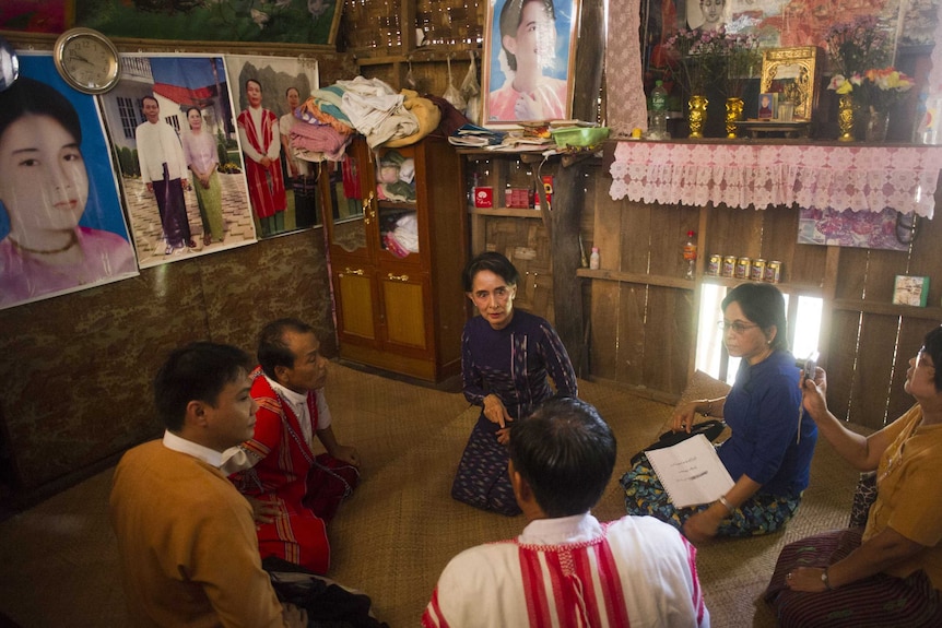 Aung San Suu Kyi (C) meets with residents during her door-to-door visit for voter education campaign in Wartheinkha, outside Yangon