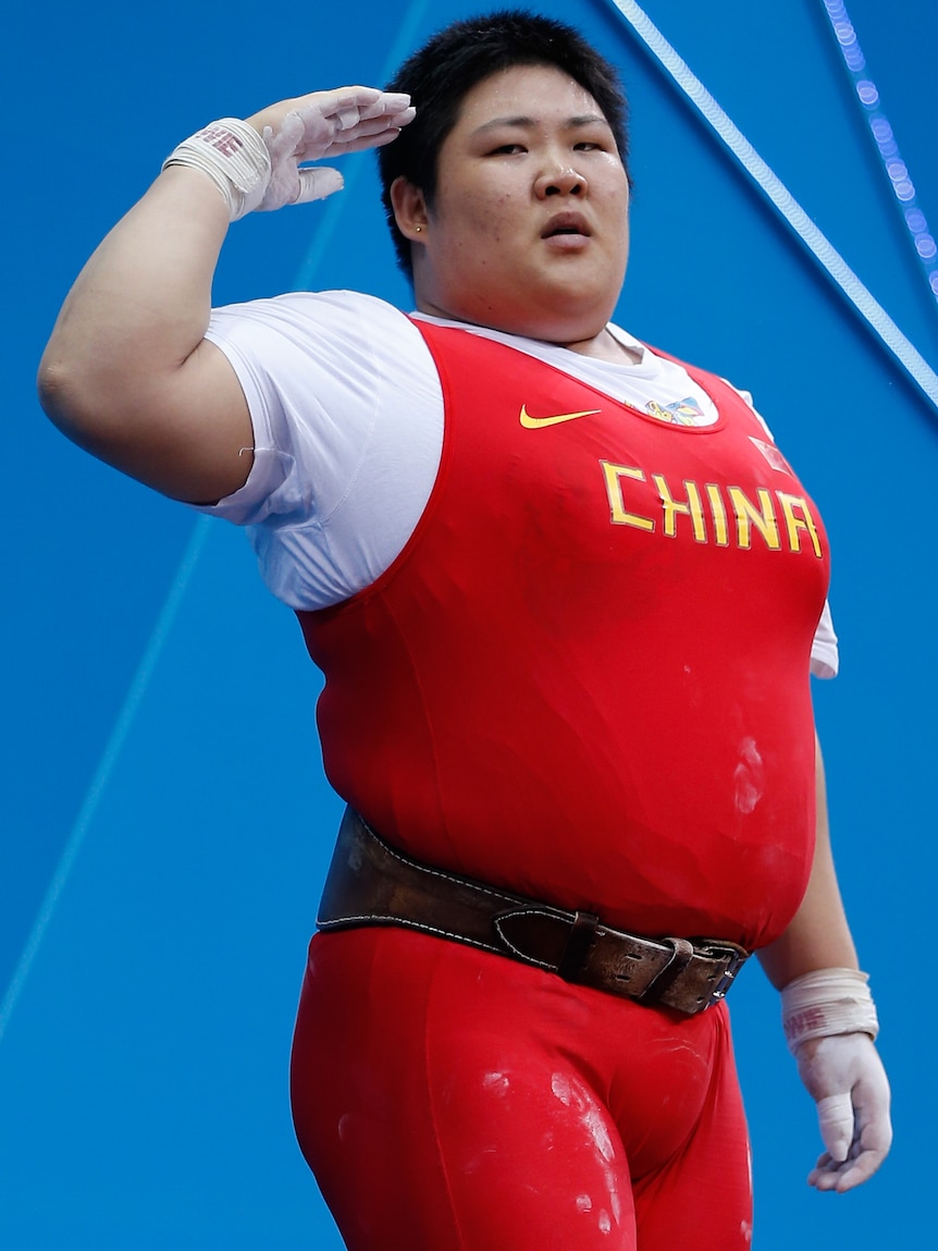 Lulu Zhou salutes in the women's 75kg weightlifting after world records in the clean and jerk and total.