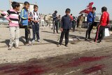 Children look at blood on the ground after a bombing in Sadr City, Baghdad.