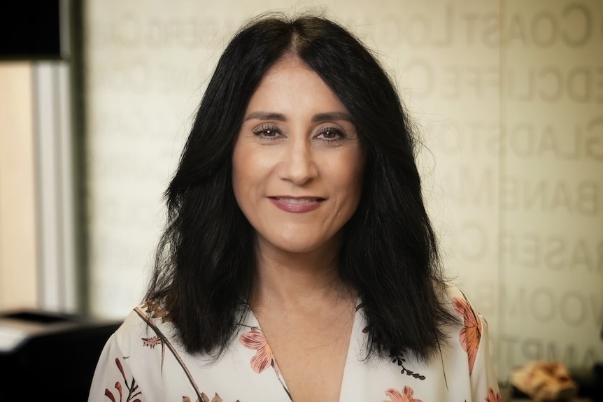 A woman smiling in a board room. 