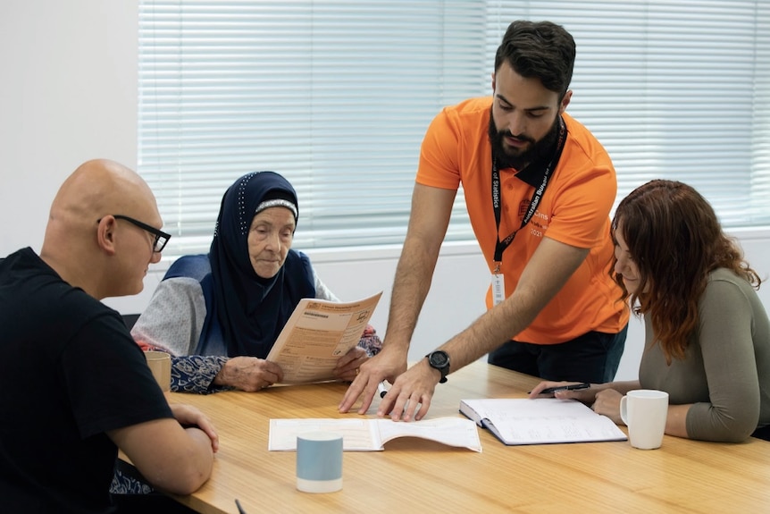 A group of people fill in census papers.