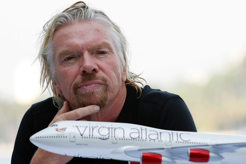 Uomo dai capelli grigi con una piccola barba con un modello di aeroplano in primo piano