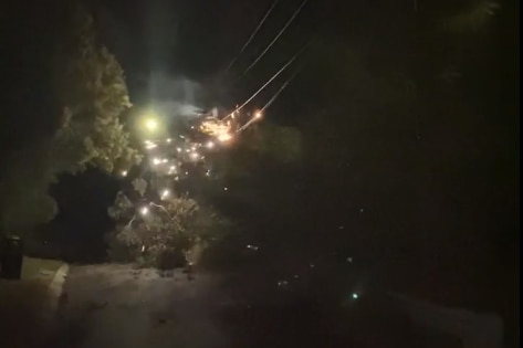 Sparks coming from power lines in the dark.