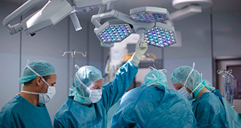 Doctors and medical staff prepare for surgery in an operating theatre.