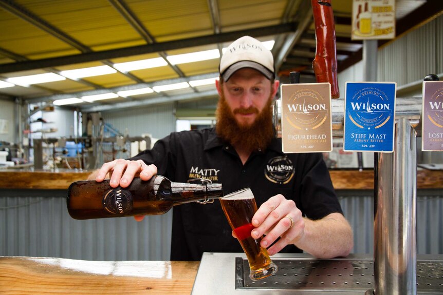 A photo of Matty Wilson pouring a beer in his new brewery
