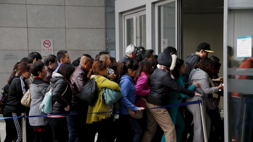 A crowd of people rush into a hospital in China.