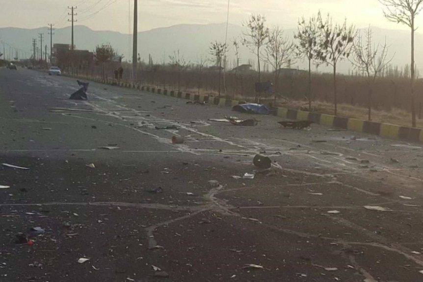 Debris is littered across a two lane road.