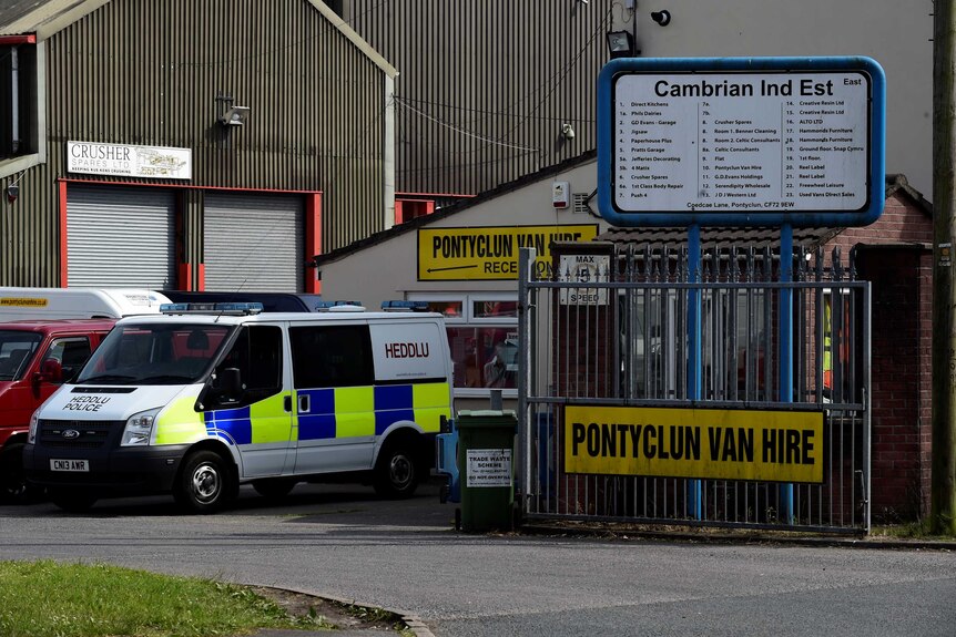 A police van sits outside a van rental place in wales where darren osborne is believed to have rented the vehicle