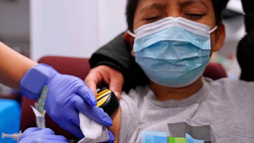 A child closes his eyes as he receives a Pfizer vaccine in Illinois, December 2021.
