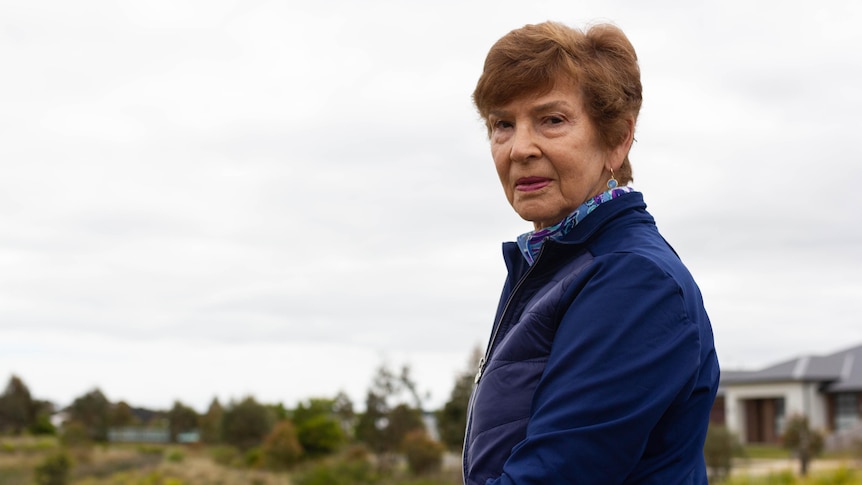 Jan Selvay stands on a viewing desk with a wetland beyond her looking down at the camera.