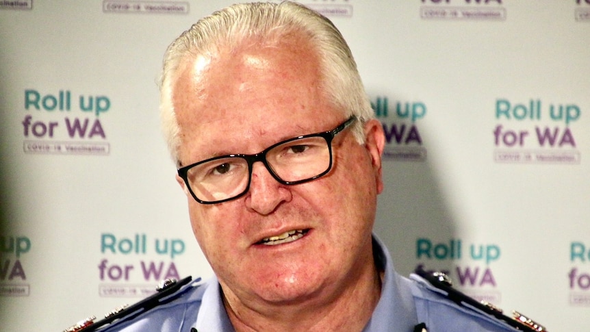 A police officer pictured in front of a 'roll up for WA' backdrop