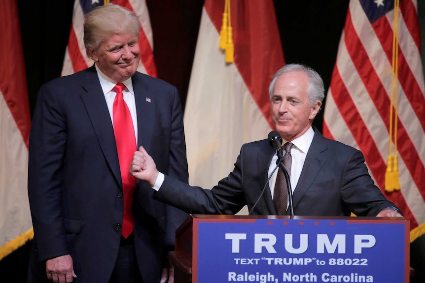 President-elect Donald Trump listens to Senator Bob Corker speaking at a rally during the US election.