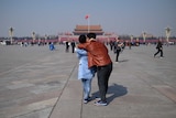 A couple hugs as they visit Tiananmen Square ahead of upcoming opening sessions of the National People's Congress