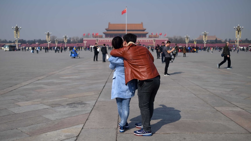 A couple hugs as they visit Tiananmen Square ahead of upcoming opening sessions of the National People's Congress