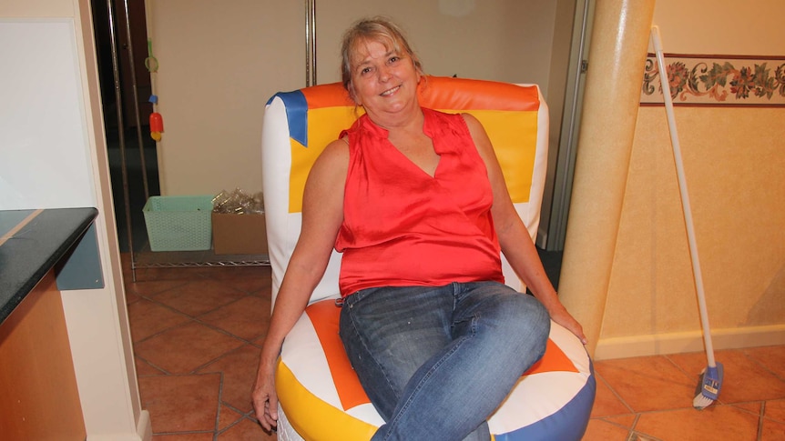 A woman sits on a colourful chair