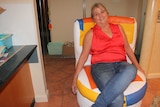 A woman sits on a colourful chair