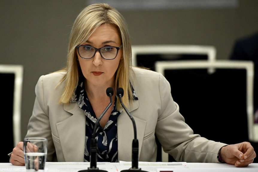 Amy Brown wearing a suit jacket and glasses