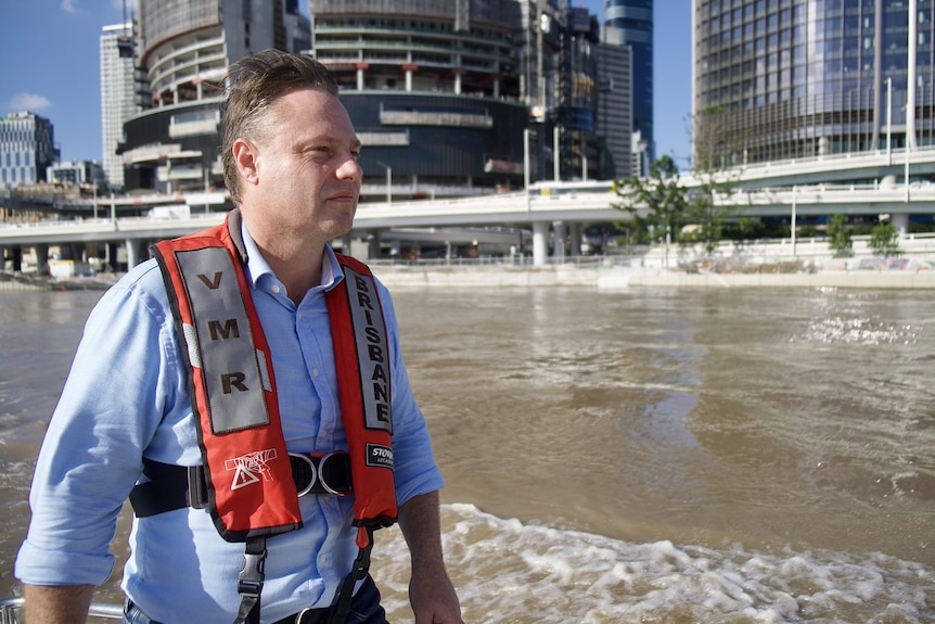 The mayor sit on a boat in the Brisbane river with a VMR vest on.