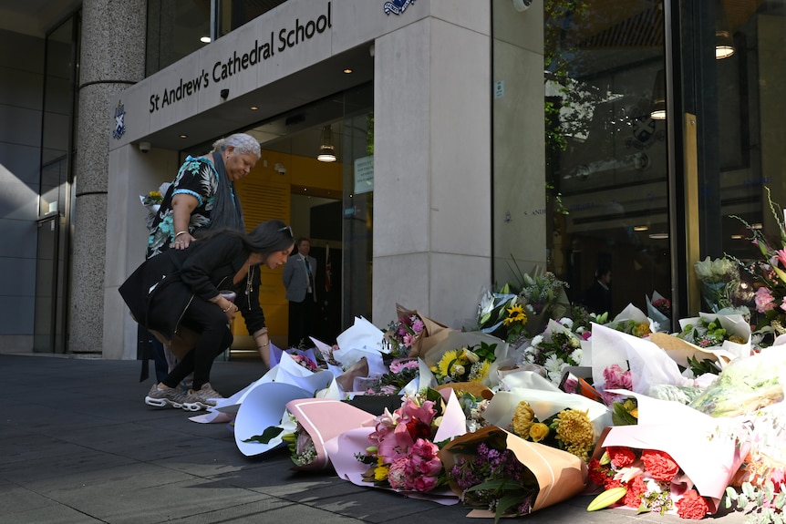 floral tributes are left outside St Andrew's Cathedral School in the Sydney CBD after the death of  waterpolo coach Lilie James