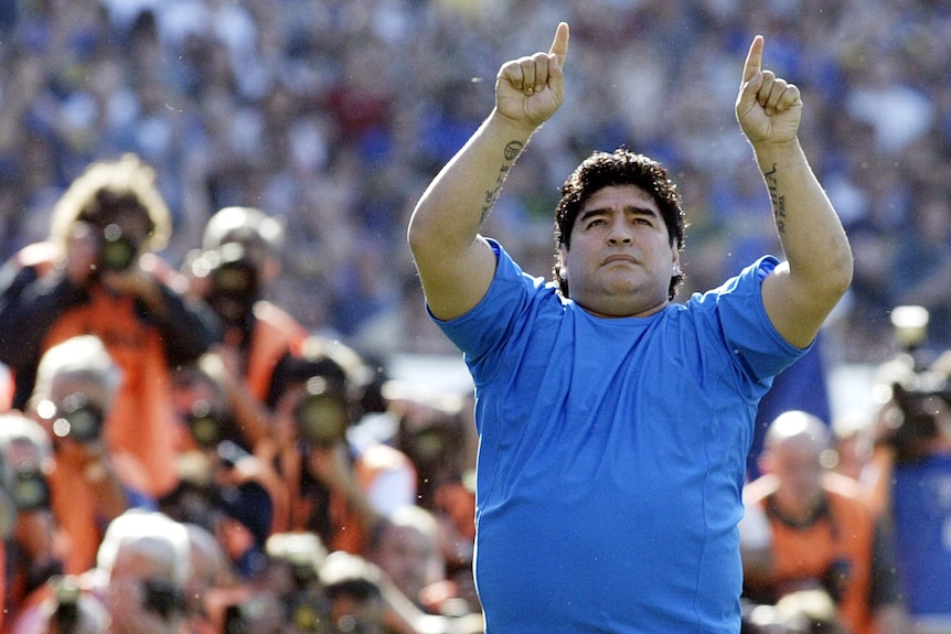 An overweight Diego Maradona salutes fans.