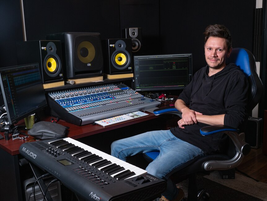 Craig Honeysett sitting at a music digital audio workstation in studio.