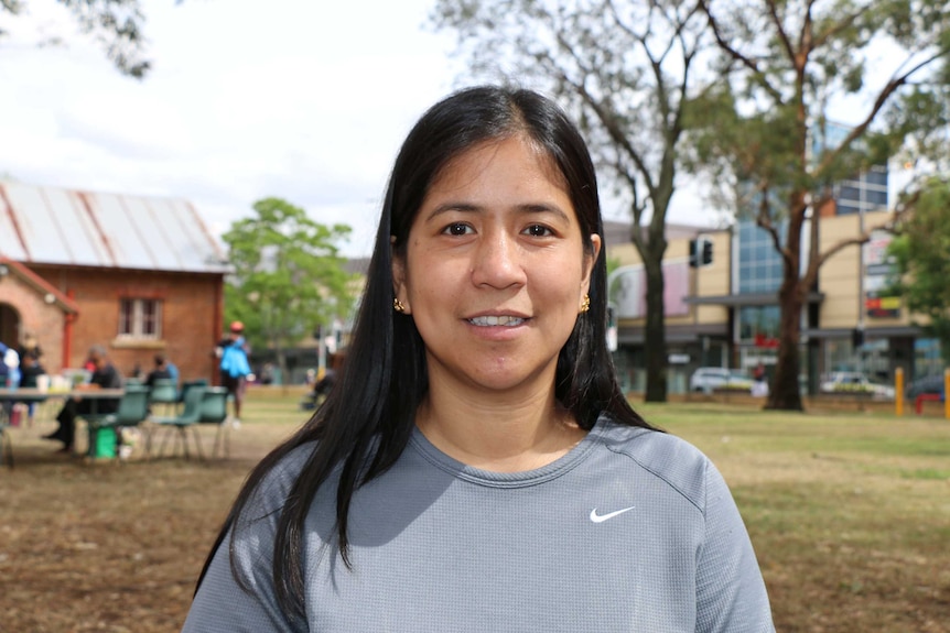 Claribel Aquino smiles in front of a playground