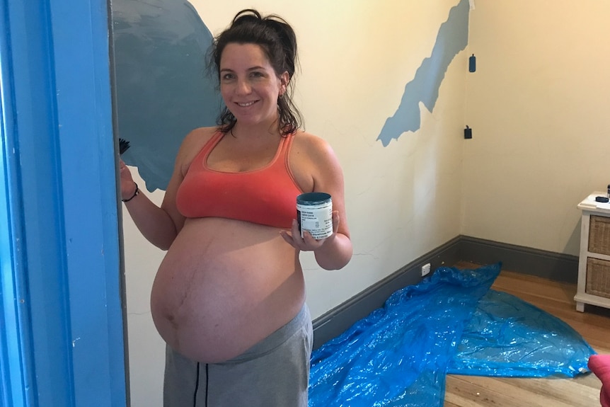 Kerri-Louise Hooper gefotografeerd terwijl ze zwanger is en de slaapkamer van een kind schildert.'s bedroom.