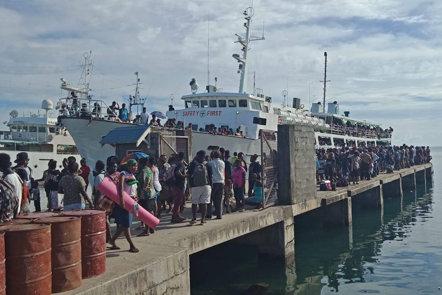 A long queue of people waiting to board a ferry at Honiara's main wharf in Solomon Islands.
