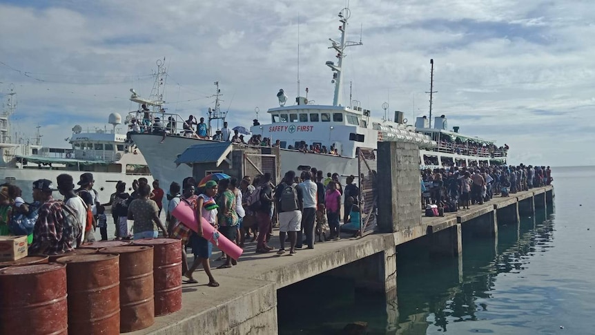 A long queue of people waiting to board a ferry at Honiara's main wharf in Solomon Islands.