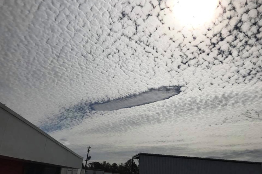 A cloud formation like a post slot in a wall of white