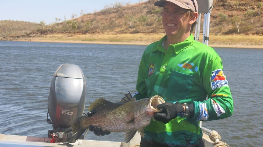 Mount Isa Fish Stocking Group president Carl Nicholson with the $50,000 tagged barramundi