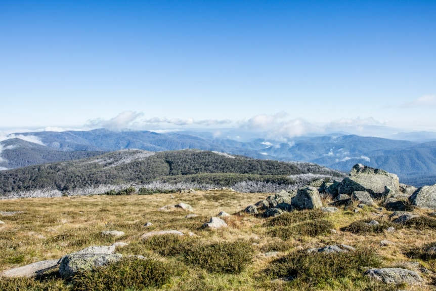 An alpine landscape looks over rolling mountains