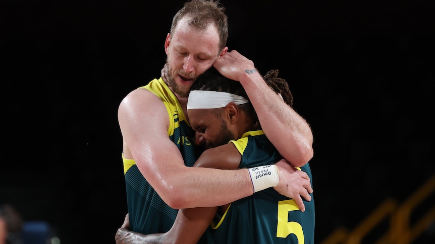 Joe Ingles hugs Patty Mills after Australia won the bronze-medal basketball game against Slovenia at the Tokyo Olympics.