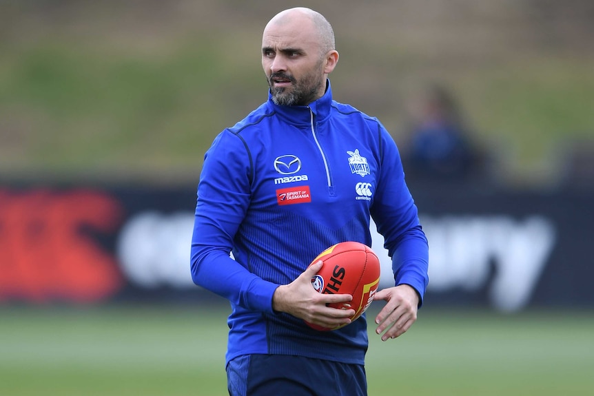 The North Melbourne AFL coach looks at a Kangaroos training session.