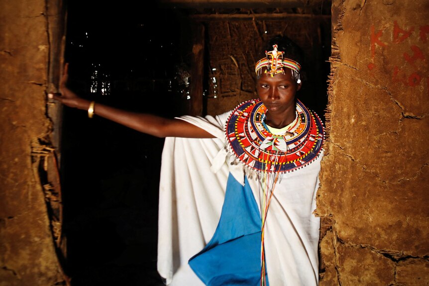 Christine Sitiyan at the entrance of a traditional mud dwelling known as Manyatta