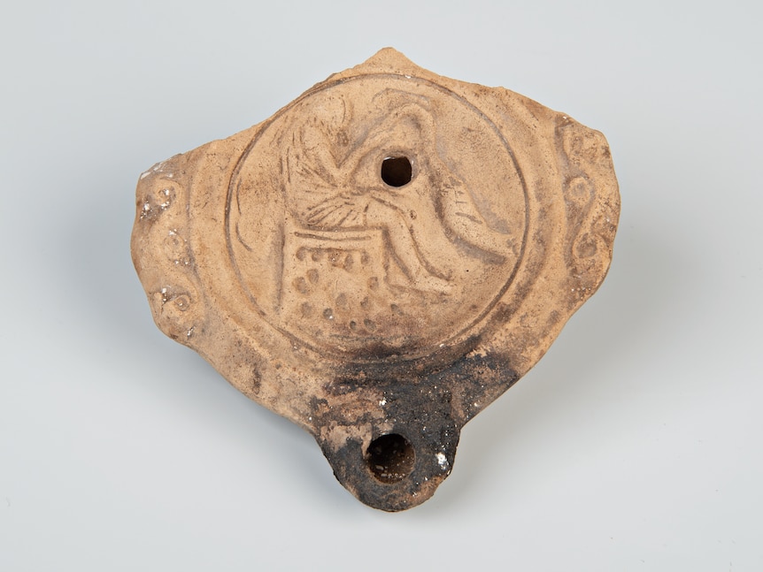 A stone oil lamp with a charred candle hole.