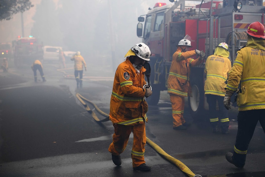 Firefighters in NSW gather round a truck as they battle bushfires