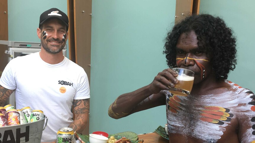 Psychologist Clinton Schultz smiles as Indigenous dancer Warrick Newbury drinks alcohol-free beer.