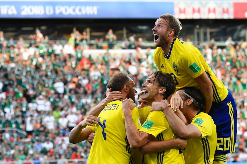 Sweden's players jump on each other to celebrate goal