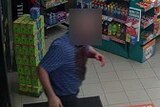 CCTV still of a man with blood down the front of his shirt.