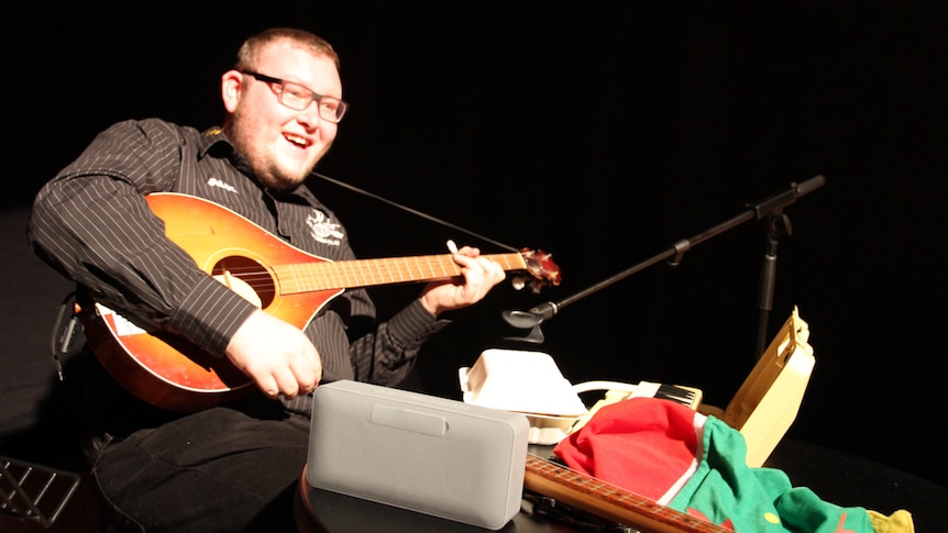 Man with musical instruments sits at table