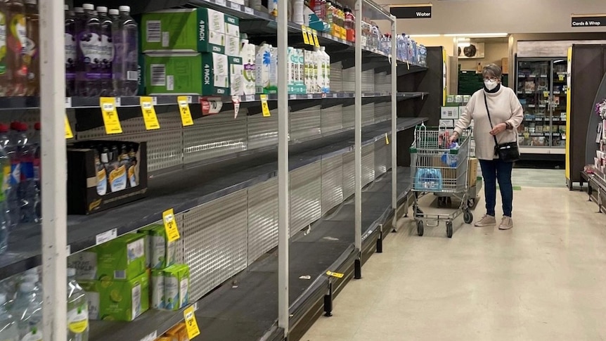 A supermarket shelf is empty, stripped bare of bottled water.