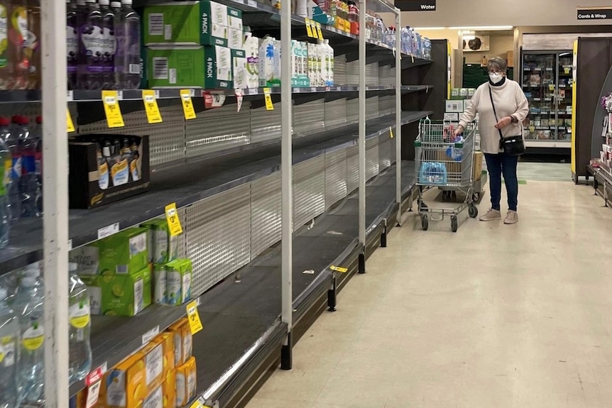 A supermarket shelf is empty, stripped bare of bottled water.