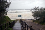 Rough seas from cyclone Hamish pound Happy Valley boardwalk on Fraser Island.