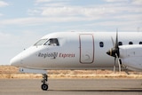 The nose of a two-propellar saab aircraft owned by Rex airlines.