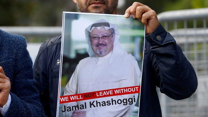 Man holding a 'Free Khashoggi' poster