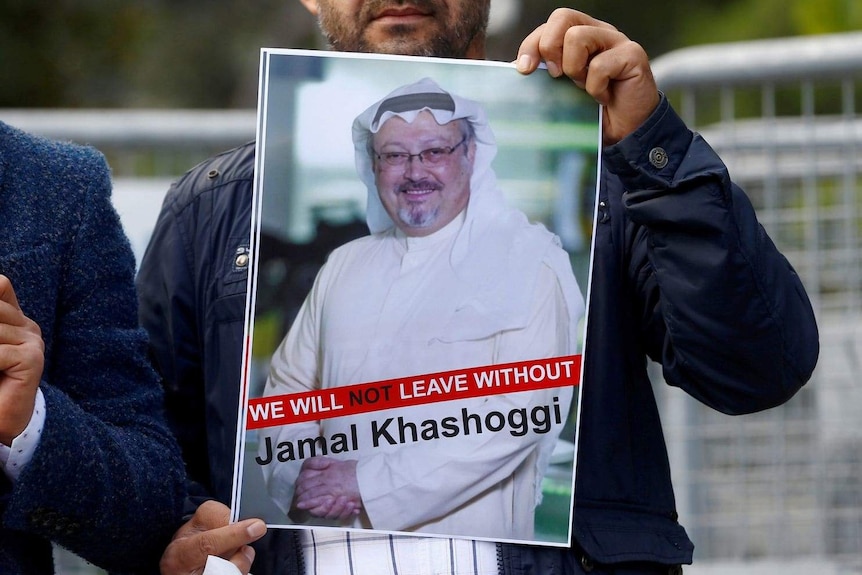 Man holding a 'Free Khashoggi' poster