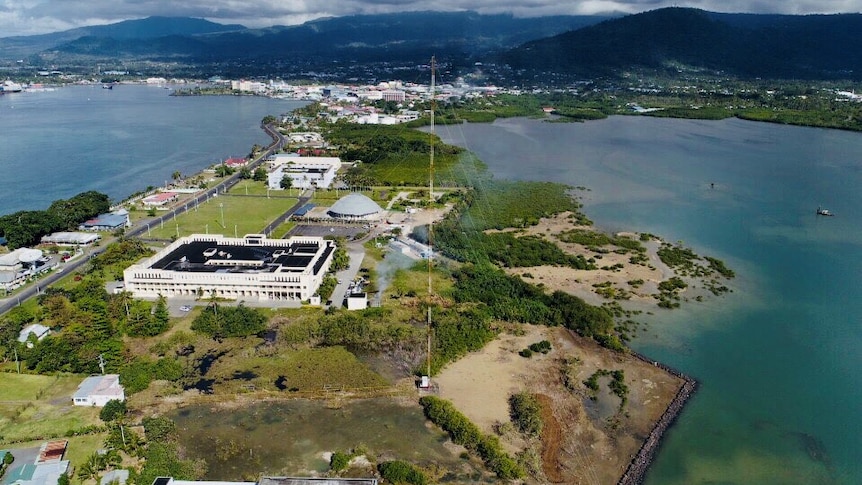 A birds eye view of the tall steel transmission tower with the backdrop of Apia in the background