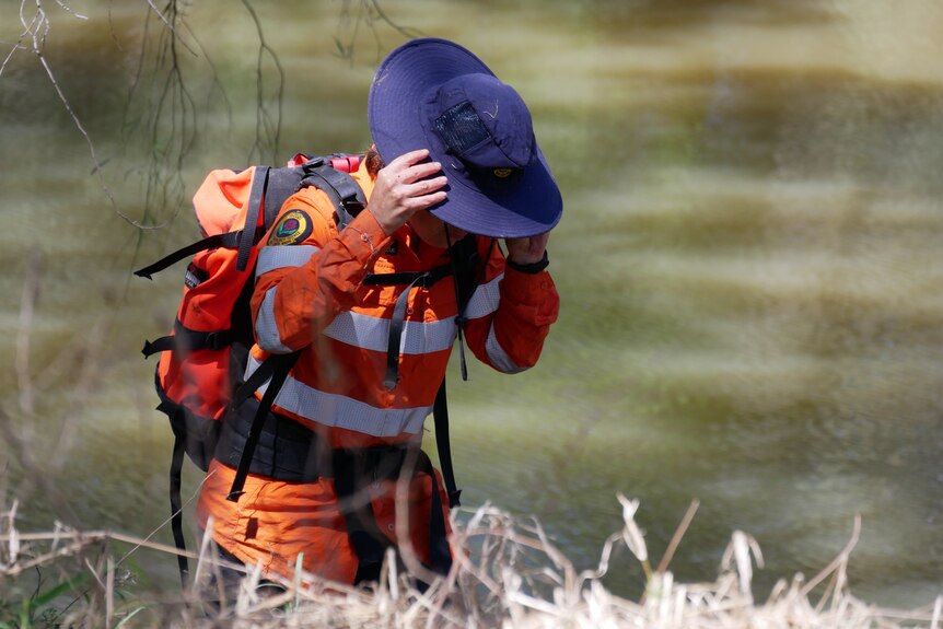 SES person with hat walking out of water