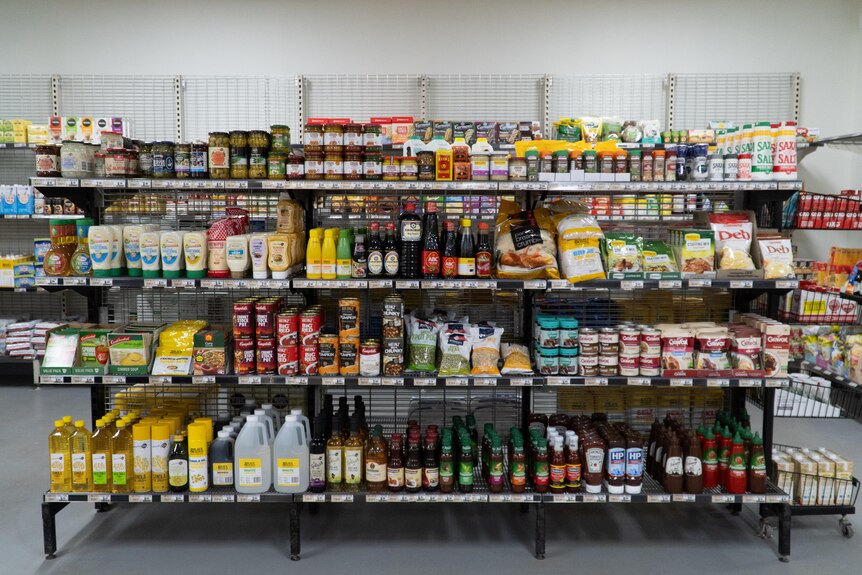 Groceries and other goods on a shelf in a supermarket.